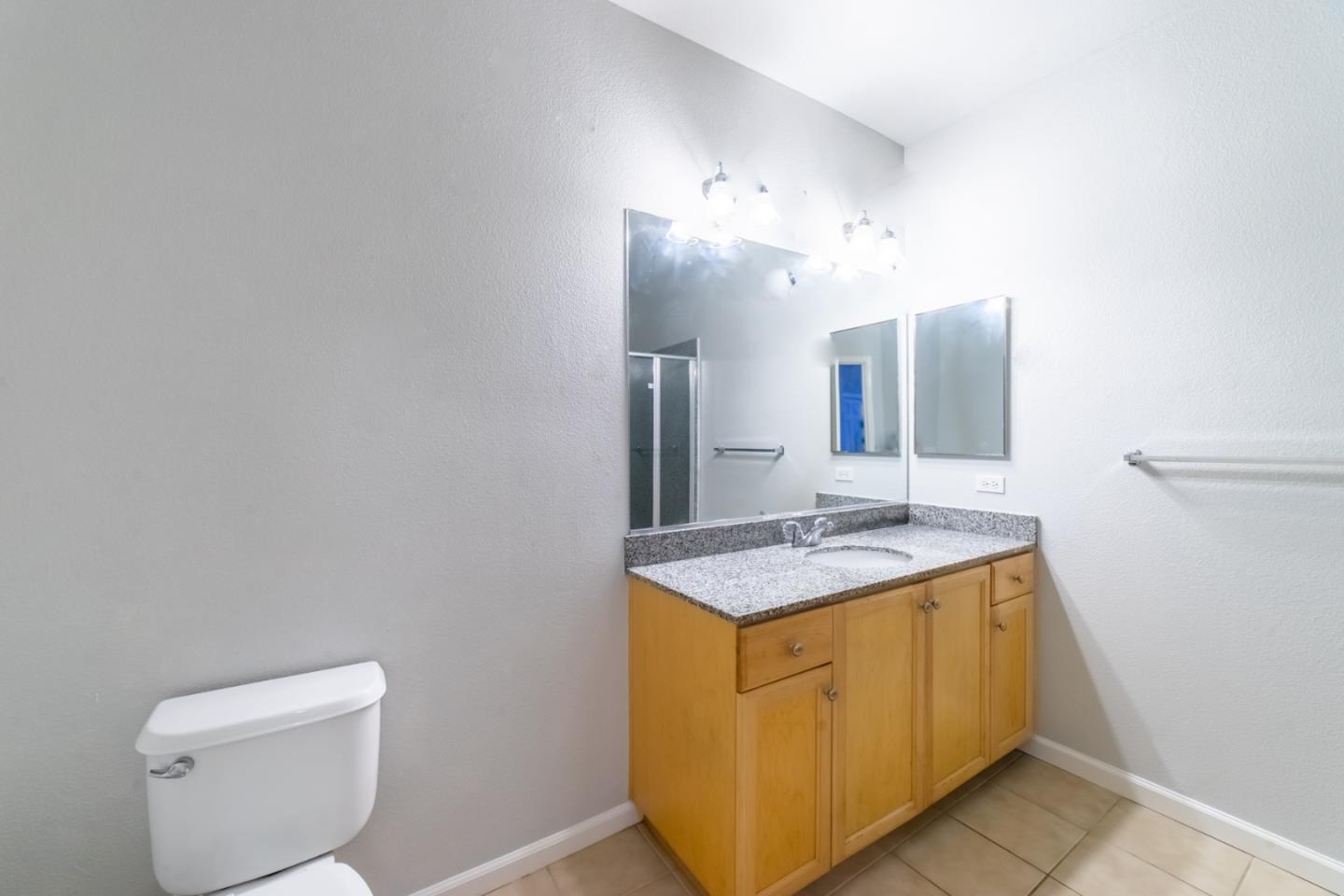 88 North Jackson Avenue, Unit 127 San Jose, CA 95116 - Photo 9 of 10 a bathroom with a granite countertop sink and a mirror