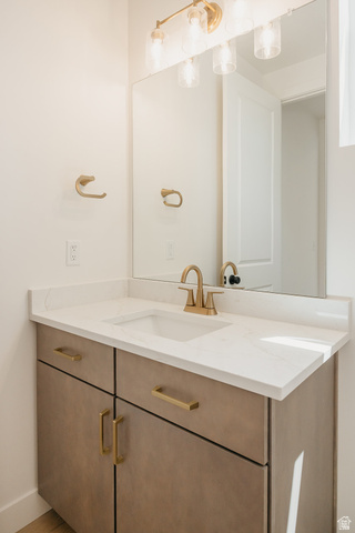 5902 Canyon Rim Road, Unit 620 Lehi, UT 84048 - Photo 75 of 78 Vanity featuring a white countertop with an integrated sink, gold-finish faucet, and coordinating gold-finish hardware on the cabinetry