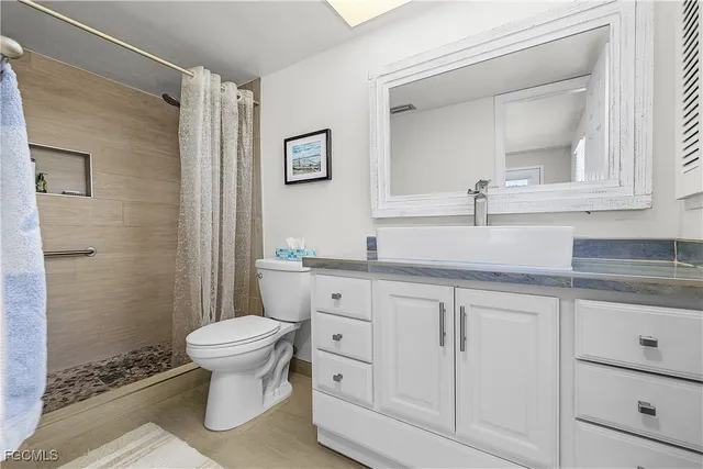 a bathroom with a granite countertop toilet sink and a mirror