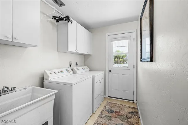 a utility room with sink dryer and washer