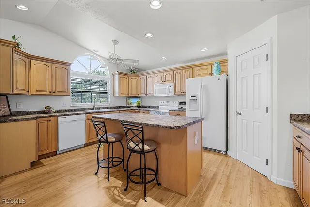 a kitchen with stainless steel appliances granite countertop a stove a sink a refrigerator and a microwave