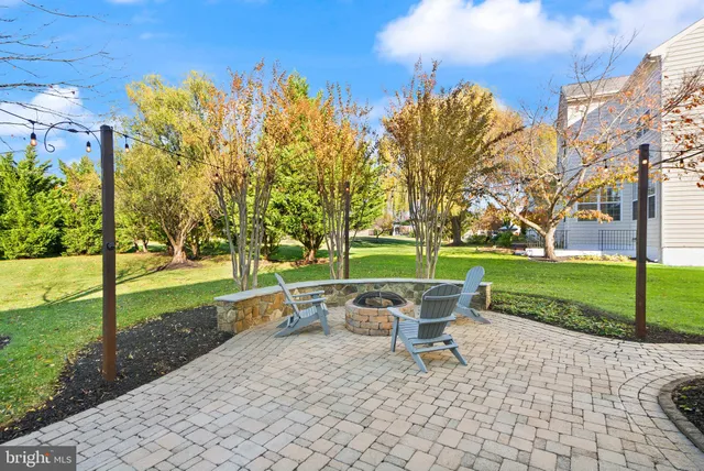 a chair and table sitting in backyard with large trees