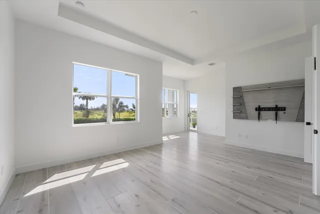 an empty room with wooden floor and window