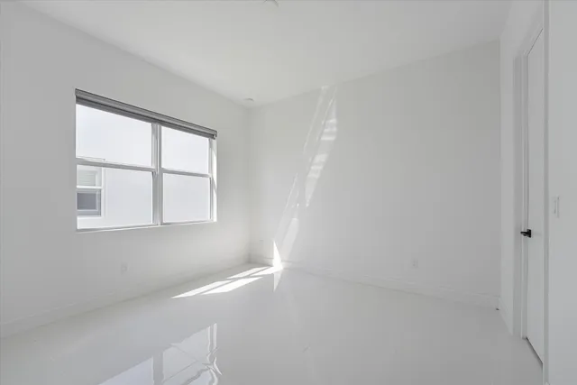 an aerial view of a residential houses with outdoor space and trees all around