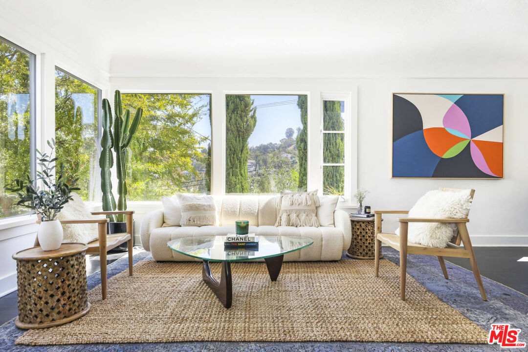 a living room with furniture a rug and a large window