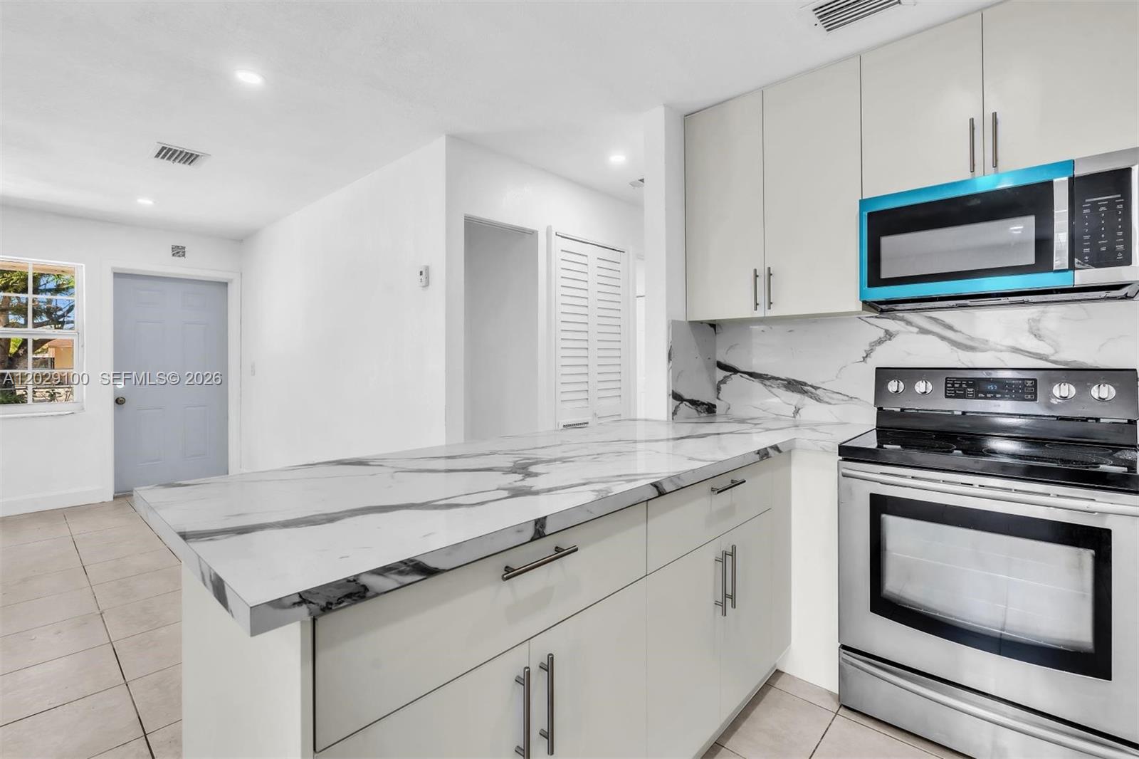 11790 Southwest 34th Street Miami, FL 33175 - Photo 17 of 56 a kitchen with stainless steel appliances granite countertop a stove and a microwave