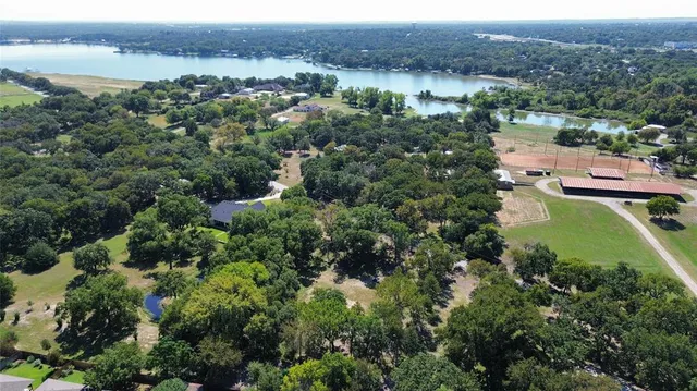 an aerial view of green landscape with trees houses and lake view