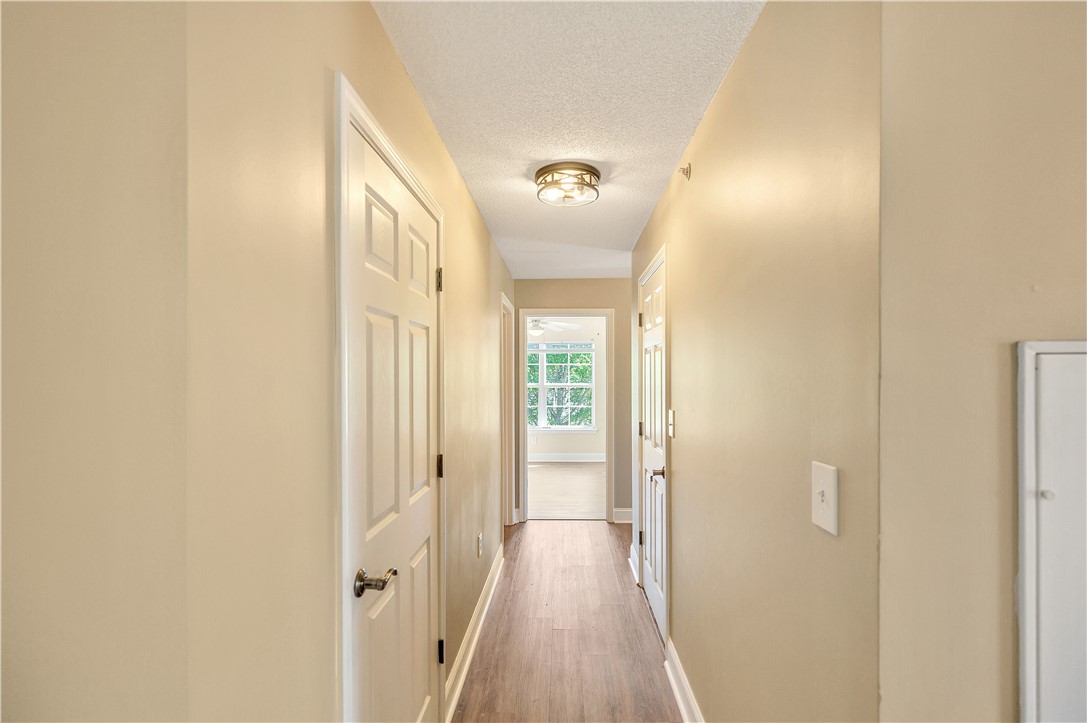726 Lookover Drive Anderson, SC 29621 - Photo 22 of 32 This interior hallway features sleek flooring and bright white trim leading to sunlit rooms.