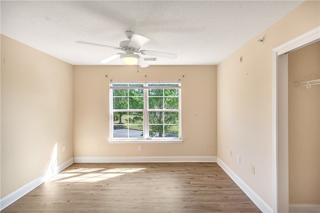 726 Lookover Drive Anderson, SC 29621 - Photo 25 of 32 Bright and airy bedroom features wood-like flooring and a window overlooking lush greenery.