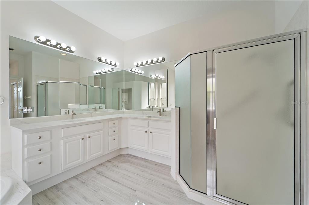 6585 Waters Edge Way Lakewood Ranch, FL 34202 - Photo 20 of 59 a spacious bathroom with a double vanity sink mirror and shower
