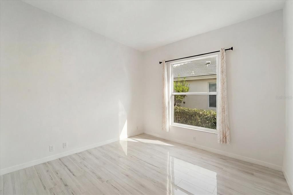 6585 Waters Edge Way Lakewood Ranch, FL 34202 - Photo 32 of 59 an empty room with wooden floor and windows