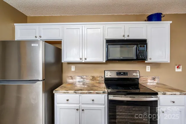 a kitchen with stainless steel appliances granite countertop a refrigerator stove and microwave