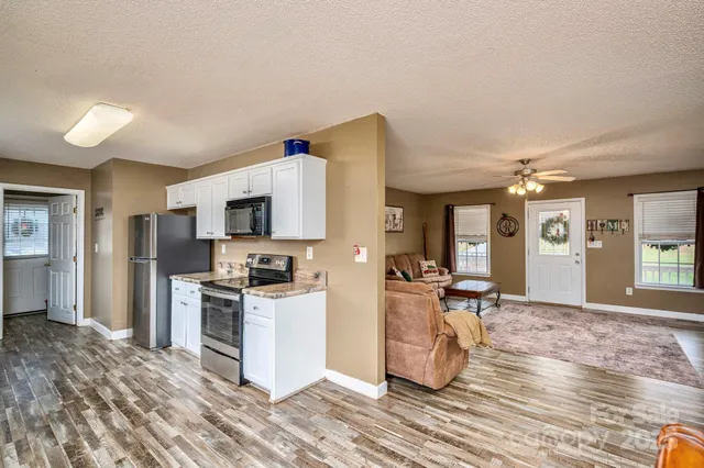 a kitchen with a sink appliances and wooden floor