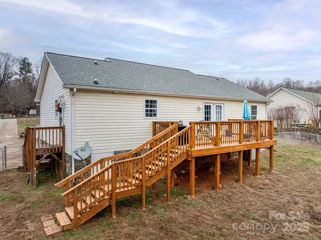 a view of a house with wooden deck and furniture