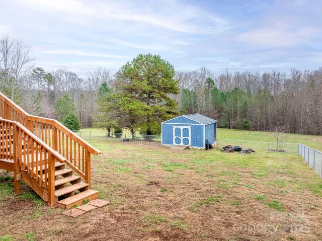 a view of a big house with a big yard and large trees