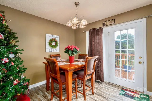 a dining room with chandelier and wooden floor