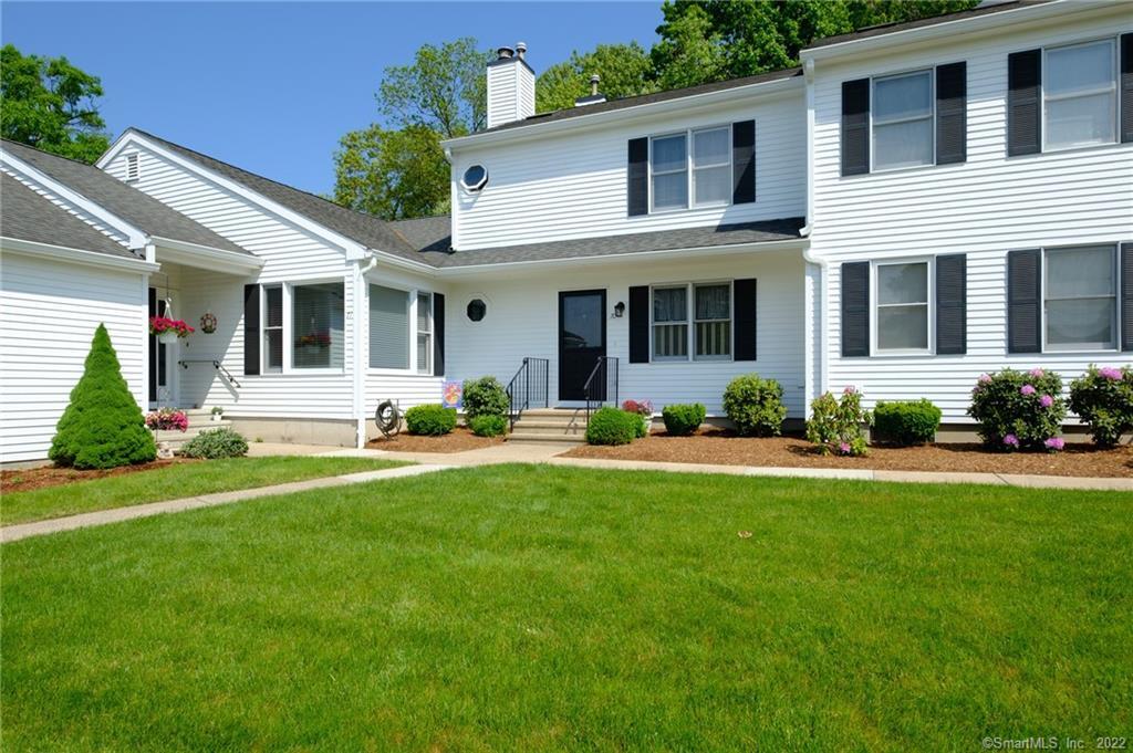 a front view of a house with porch and garden