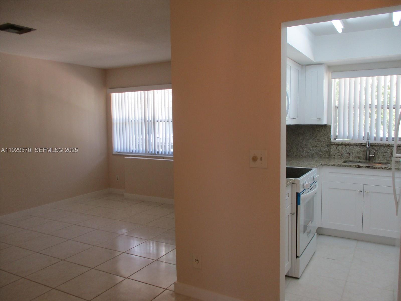 3500 Harrison Street, Unit 11 Hollywood, FL 33021 - Photo 6 of 16 a kitchen with white cabinets and window