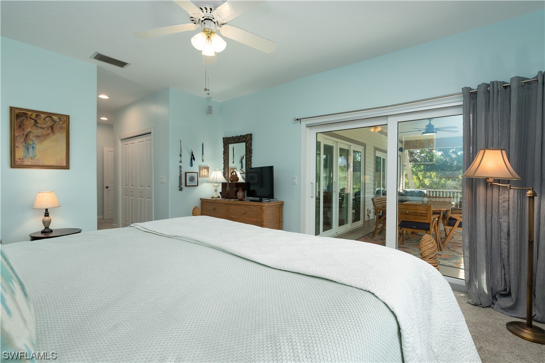2130 Sunset Circle Sanibel, FL 33957 - Photo 18 of 36 a bedroom with a large bed and a chandelier