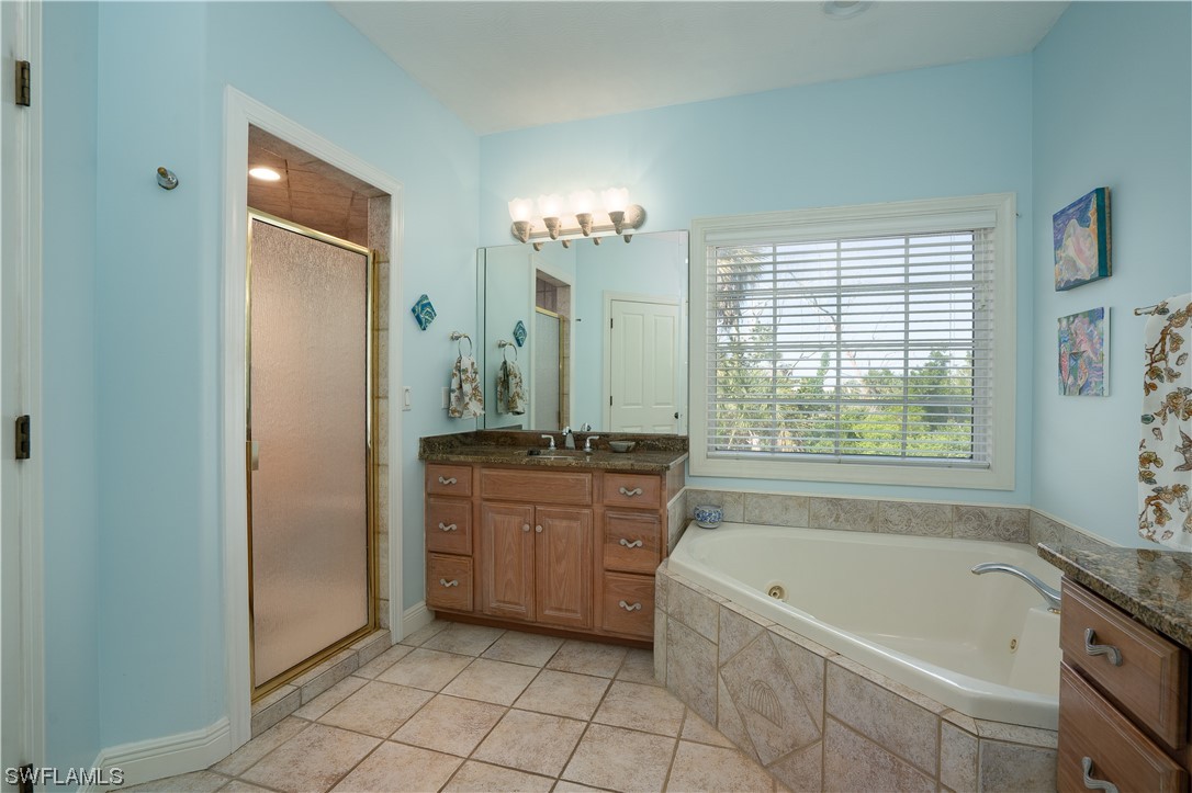 2130 Sunset Circle Sanibel, FL 33957 - Photo 20 of 36 a bathroom with a granite countertop tub a sink and a mirror