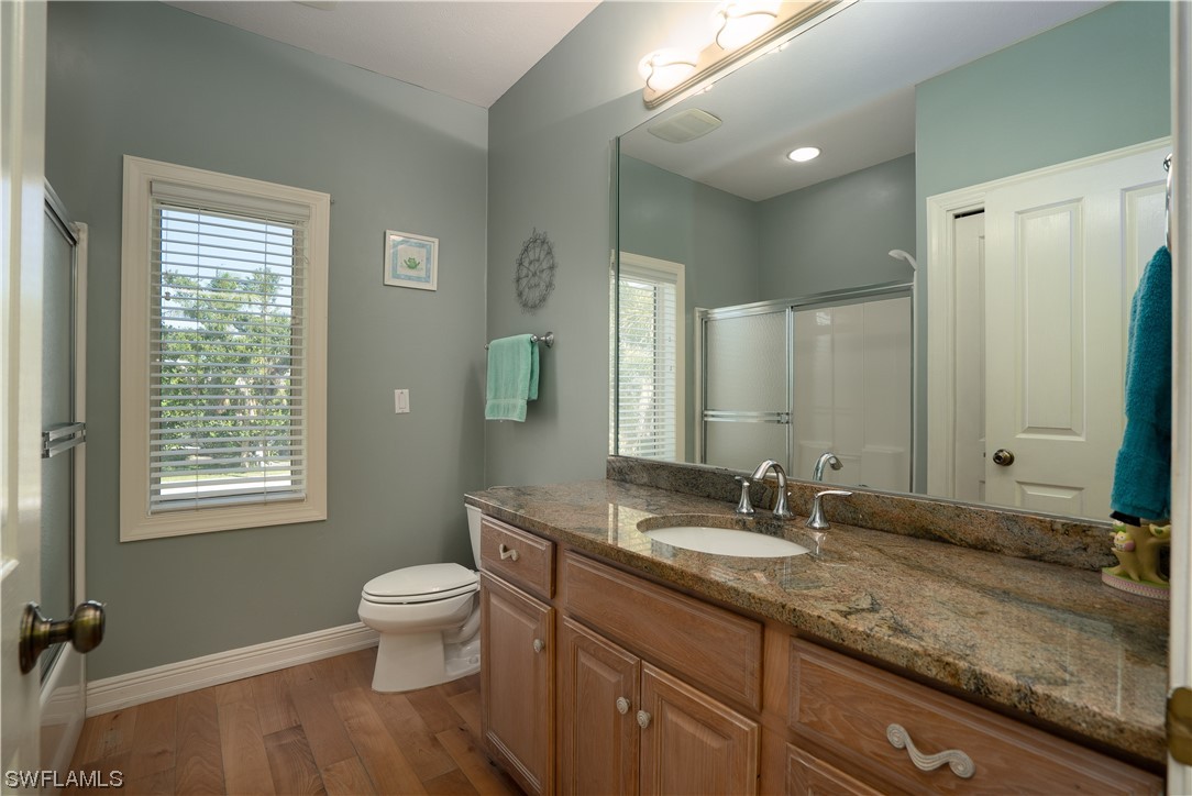 2130 Sunset Circle Sanibel, FL 33957 - Photo 23 of 36 a bathroom with a granite countertop sink toilet a large mirror and shower