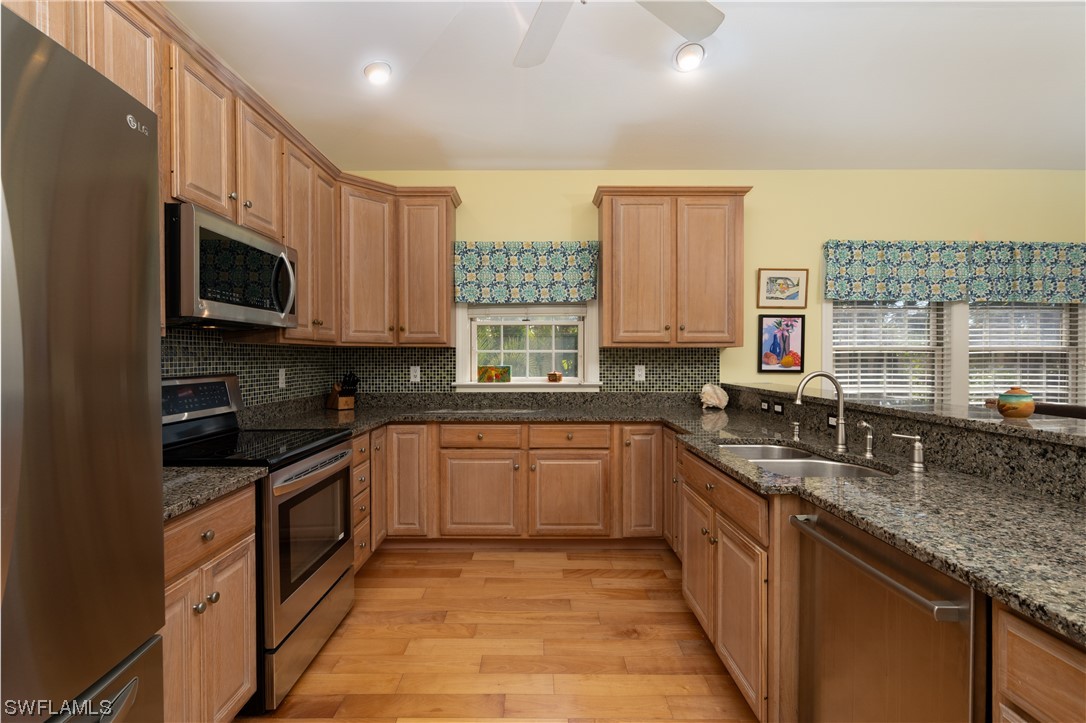 2130 Sunset Circle Sanibel, FL 33957 - Photo 7 of 36 a kitchen with stainless steel appliances granite countertop a sink stove microwave and cabinets
