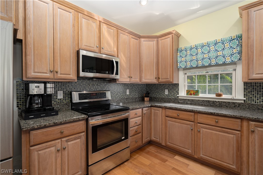 2130 Sunset Circle Sanibel, FL 33957 - Photo 9 of 36 a kitchen with granite countertop white cabinets stainless steel appliances and a sink