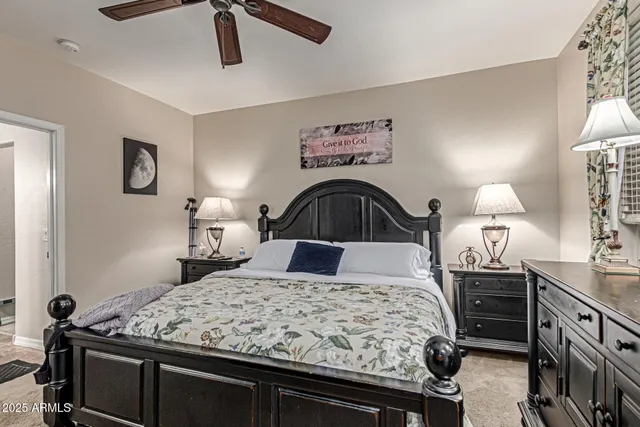 a bedroom with a bed and a lamp on dresser