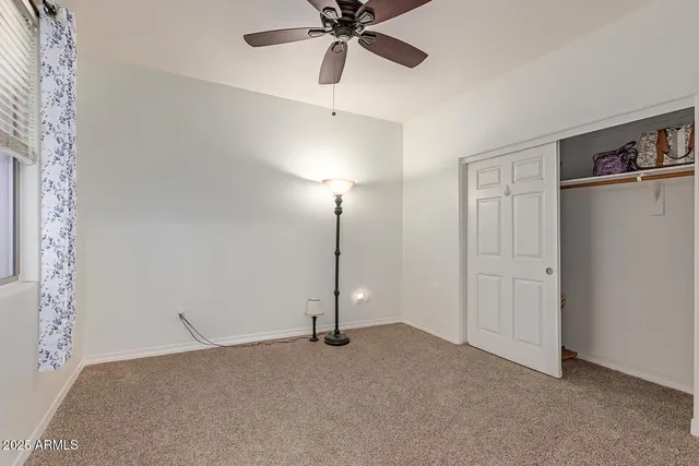 a view of a room with closet and a ceiling fan