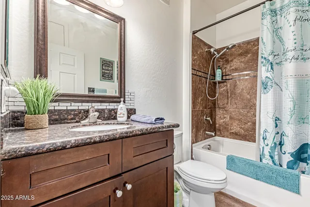 a bathroom with a granite countertop sink toilet a large mirror a bathtub and shower