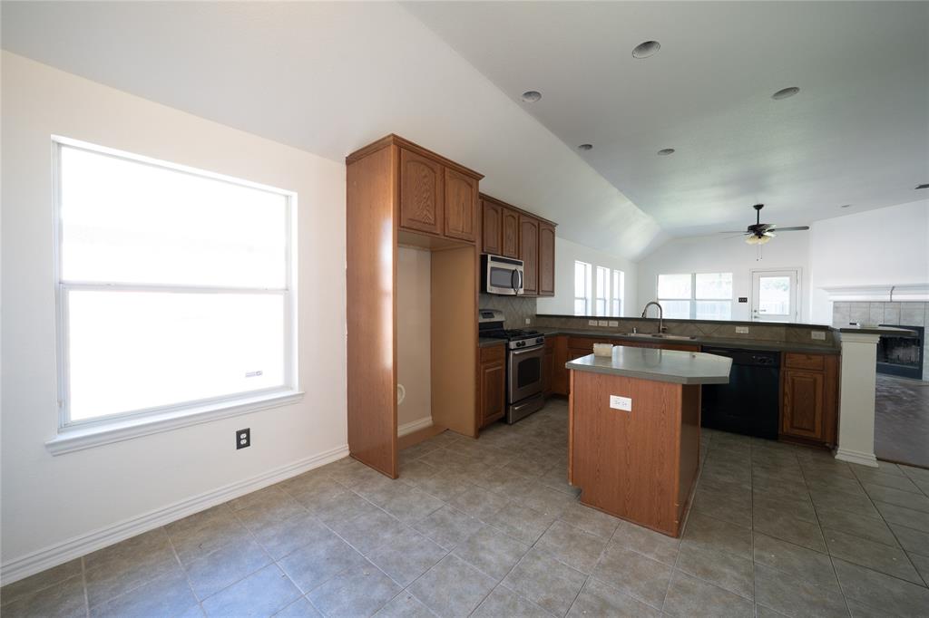 317 Parakeet Drive Little Elm, TX 75068 - Photo 11 of 17 a kitchen with stainless steel appliances kitchen island a sink stove and refrigerator
