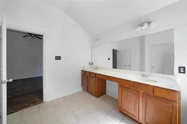 a spacious bathroom with double vanity and a mirror