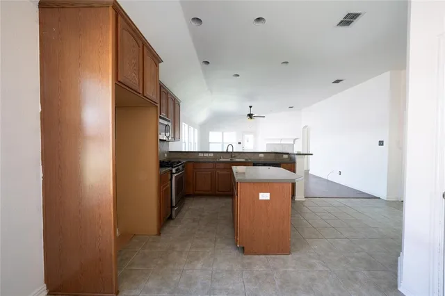 a kitchen with stainless steel appliances a refrigerator a sink a stove and a microwave