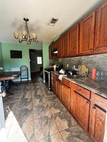a kitchen with stainless steel appliances granite countertop a stove a sink dishwasher and cabinets with wooden floor