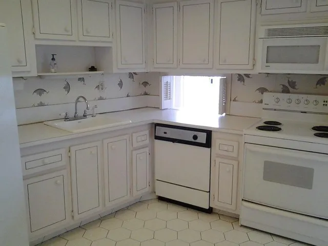 a kitchen with white cabinets and white appliances