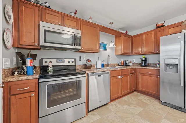 a kitchen with stainless steel appliances granite countertop a refrigerator stove top oven a sink and dishwasher
