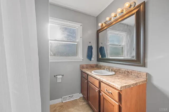 a bathroom with a granite countertop sink and a mirror
