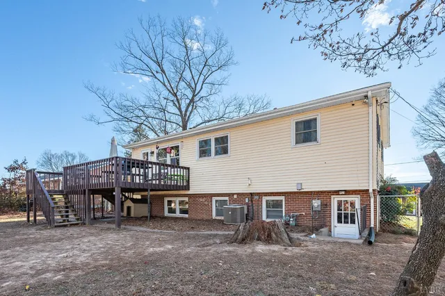 a view of a house with a wooden deck and a backyard