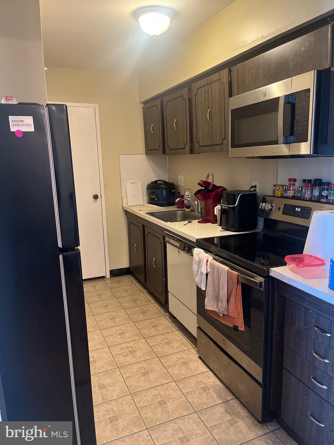 7600 Roosevelt Boulevard, Unit 806 Philadelphia, PA 19152 - Photo 15 of 16 a kitchen with stainless steel appliances granite countertop a stove a sink and a microwave