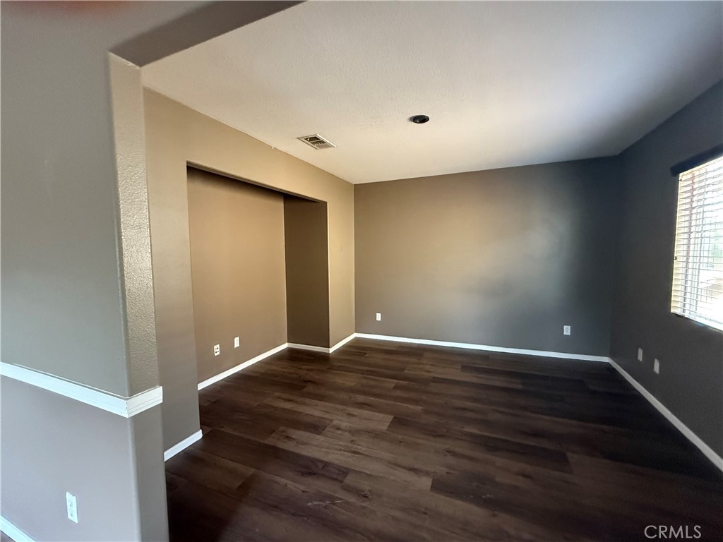 1264 Reisling Drive Perris, CA 92571 - Photo 12 of 15 a view of an empty room with wooden floor and a window
