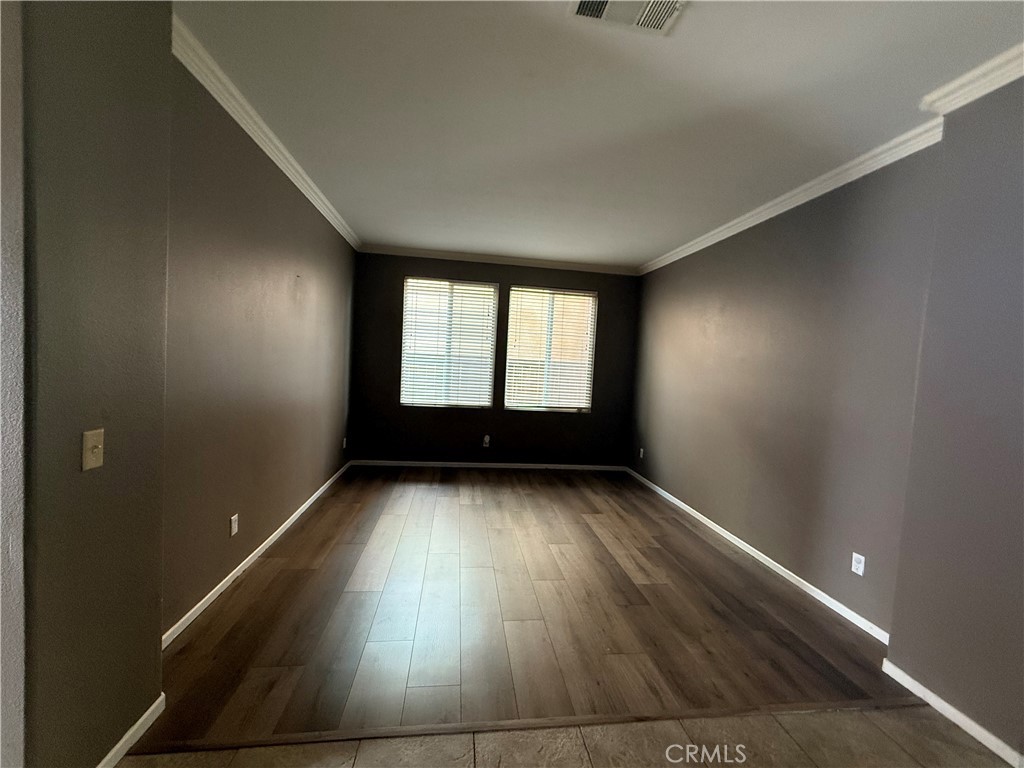 1264 Reisling Drive Perris, CA 92571 - Photo 7 of 15 an empty room with wooden floor and windows