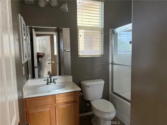 a bathroom with a toilet a sink and a large mirror
