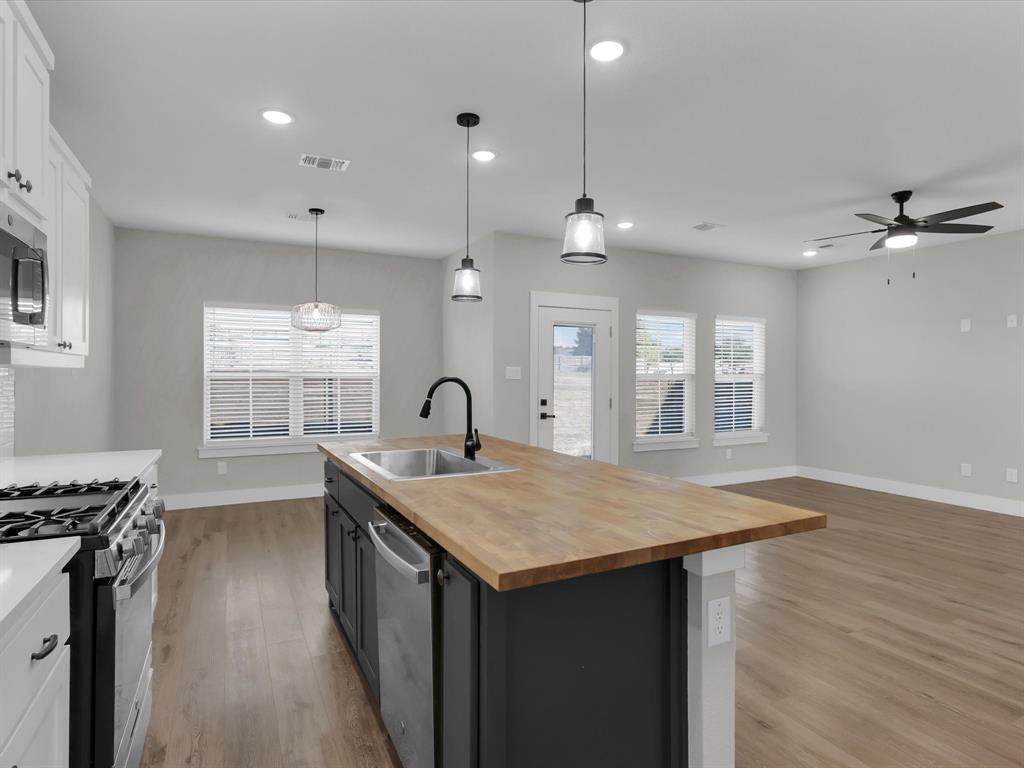 4905 Sweetbay Road Sherman, TX 75092 - Photo 8 of 26 a kitchen with stainless steel appliances granite countertop a stove a sink dishwasher and a refrigerator with wooden floor