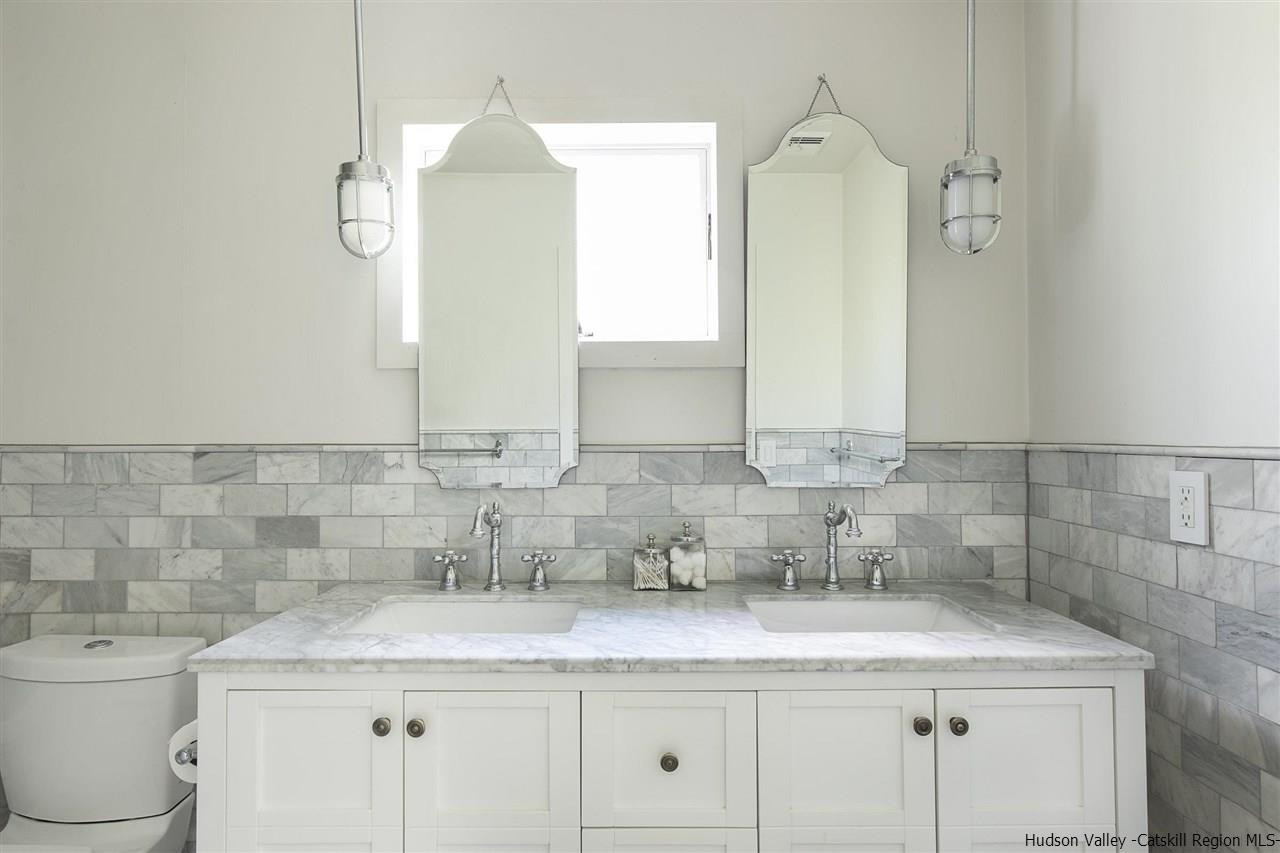 128 Bakertown Road Accord, NY 12404 - Photo 16 of 23 a bathroom with a granite countertop sink a toilet and mirror