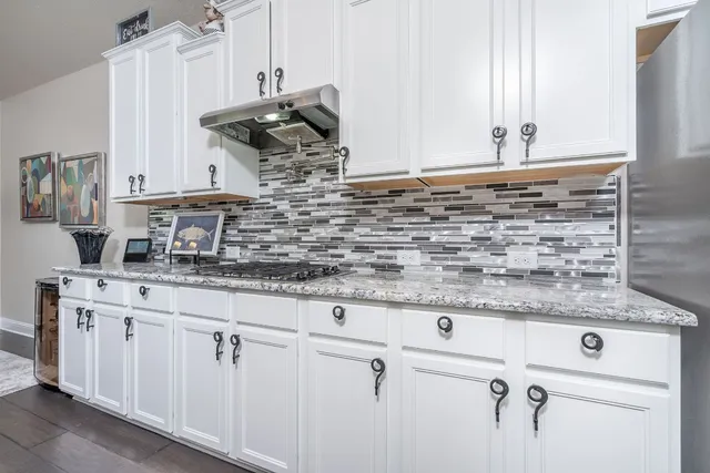 a kitchen with granite countertop a sink and cabinets