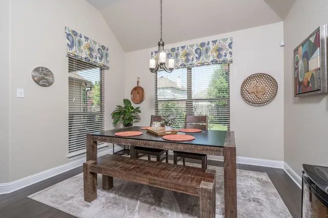 a view of a dining room that has a table and a chandelier