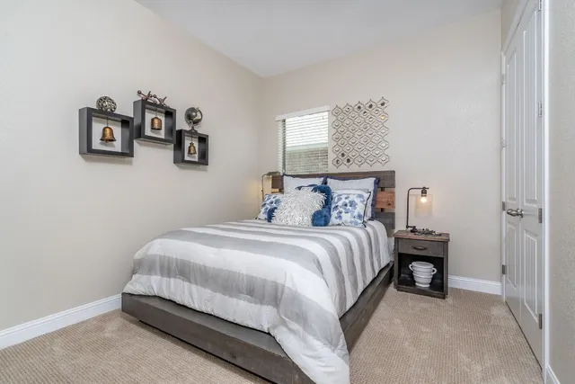 a bedroom with a bed and painting on the wall