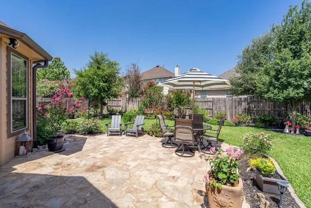 a view of a patio with table and chairs under an umbrella