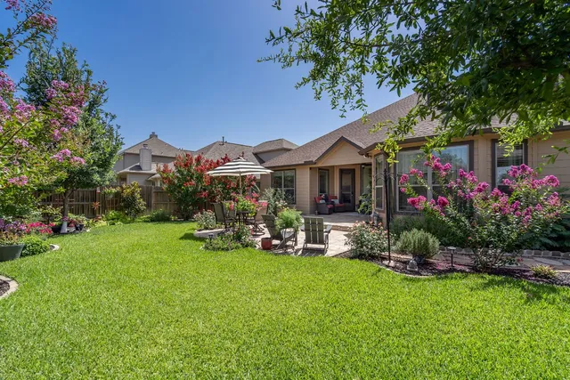 a view of a house with a garden and sitting area