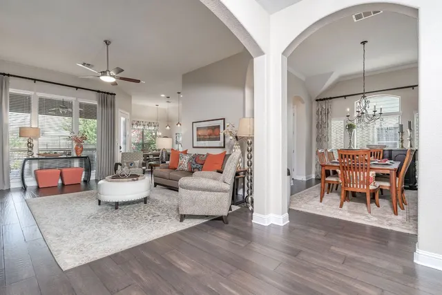a living room with furniture or chandelier and a wooden floor